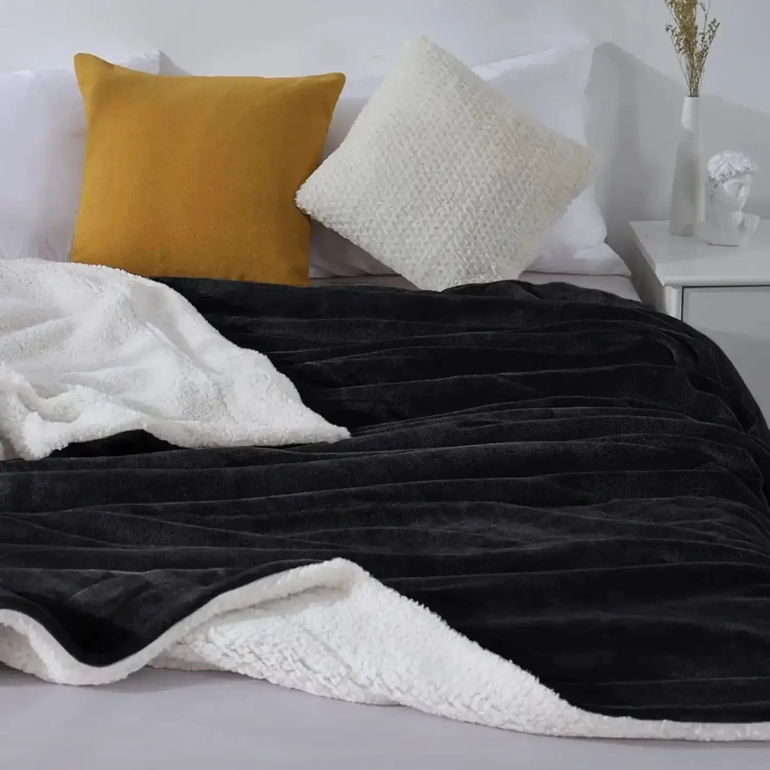 Couverture en peluche noir et blanc avec une texture douce et veloutée.