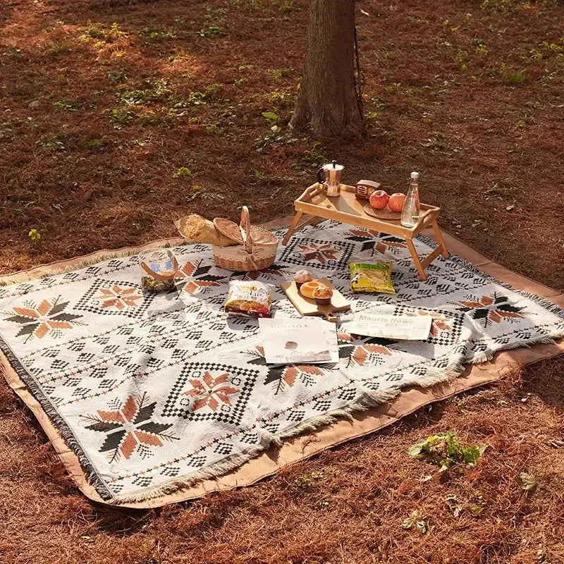 Tapis de pique-nique bohème motifs géométriques avec franges posé en forêt