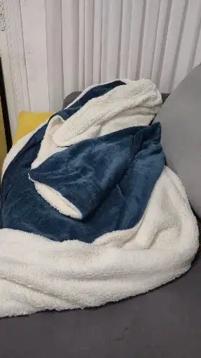 Une couverture en polaire douce bleu marine et blanc avec une surface texturée douce.