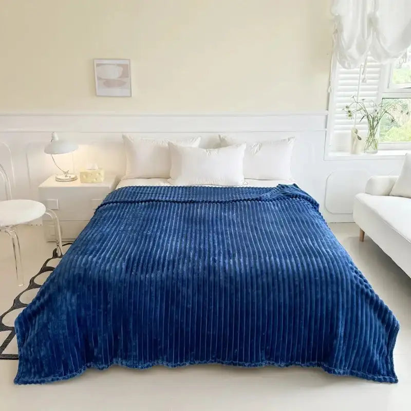 Couverture en velours côtelé bleu profond avec une texture moelleuse et côtelée.