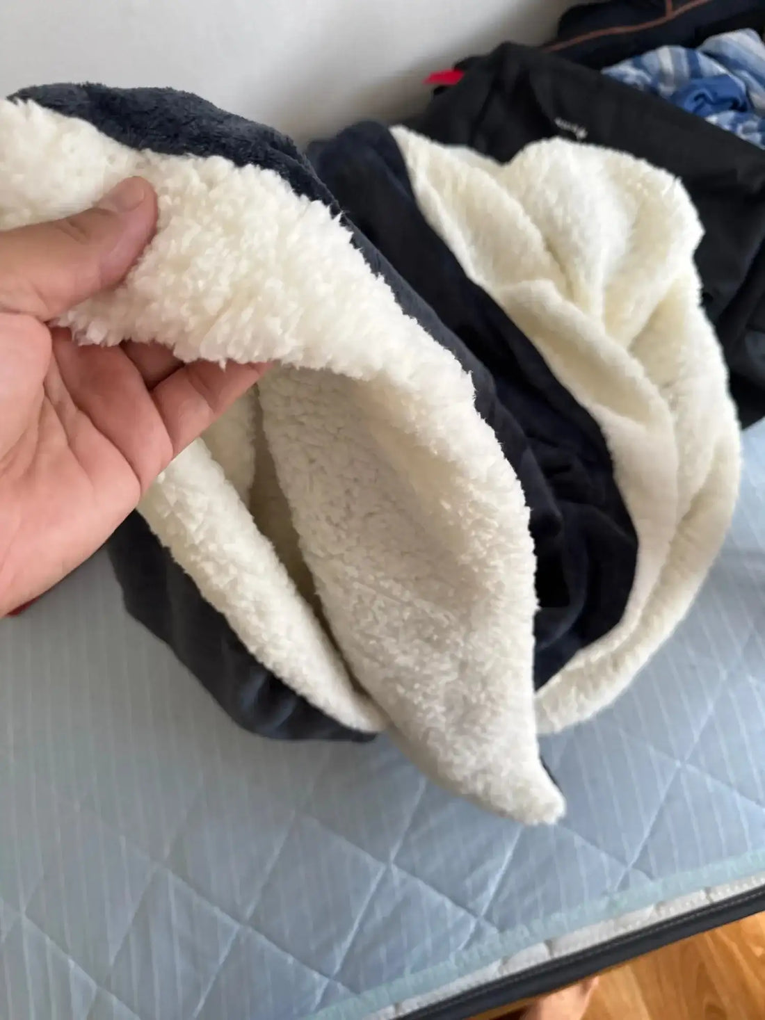 Un vêtement douillet doublé de sherpa noir et blanc avec un intérieur doux et moelleux.